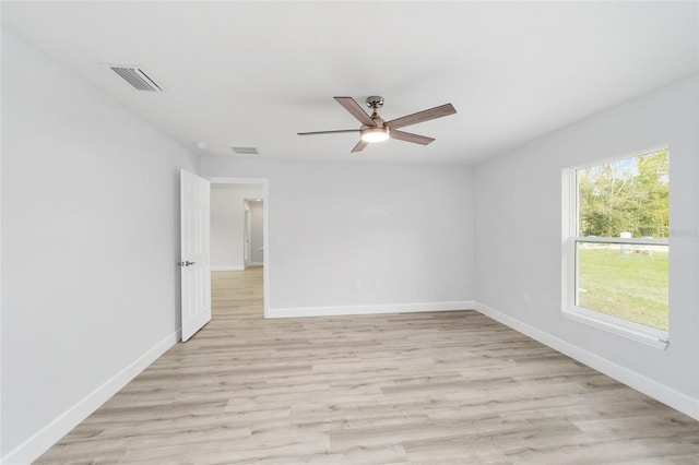 unfurnished room with light wood-type flooring, visible vents, and baseboards