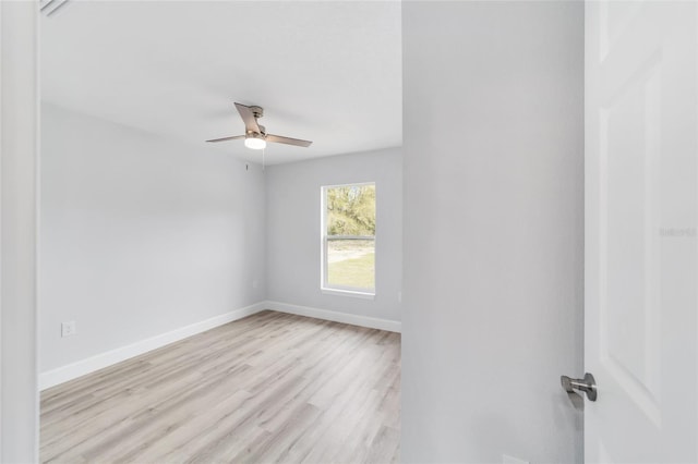 spare room with light wood finished floors, baseboards, and a ceiling fan