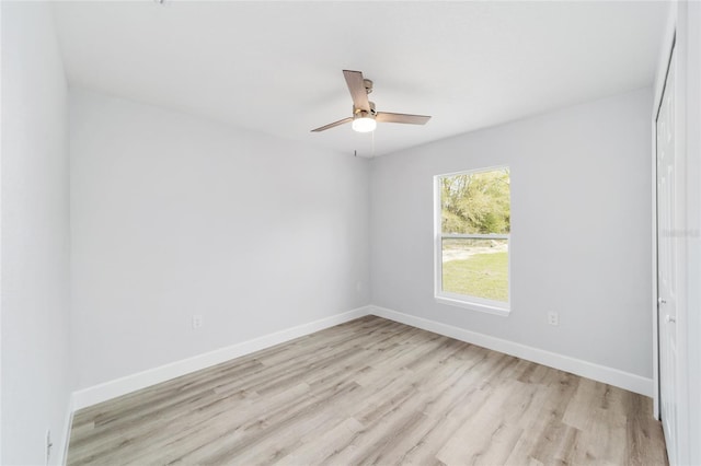 spare room featuring ceiling fan, light wood-style flooring, and baseboards