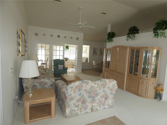 living area with visible vents, ceiling fan, vaulted ceiling, carpet flooring, and french doors