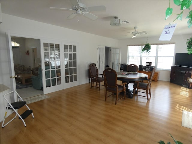 dining space featuring french doors, visible vents, ceiling fan, and light wood finished floors