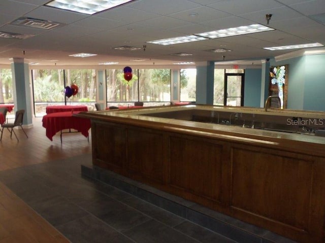 interior space with a paneled ceiling, visible vents, and wood finished floors