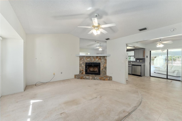 unfurnished living room with vaulted ceiling, visible vents, a fireplace, and a textured ceiling