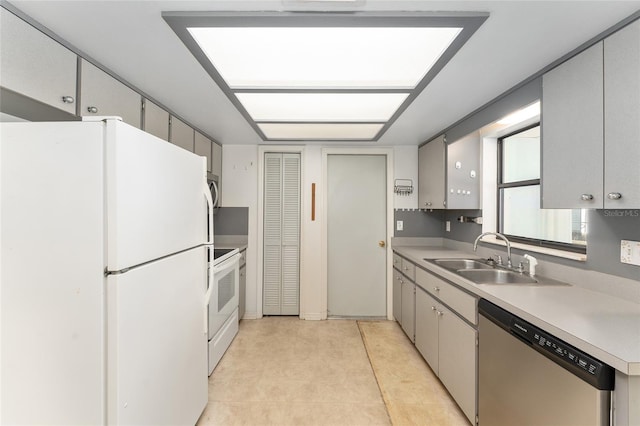 kitchen with stainless steel appliances, light tile patterned flooring, a sink, and light countertops