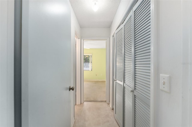 corridor featuring baseboards and a textured ceiling