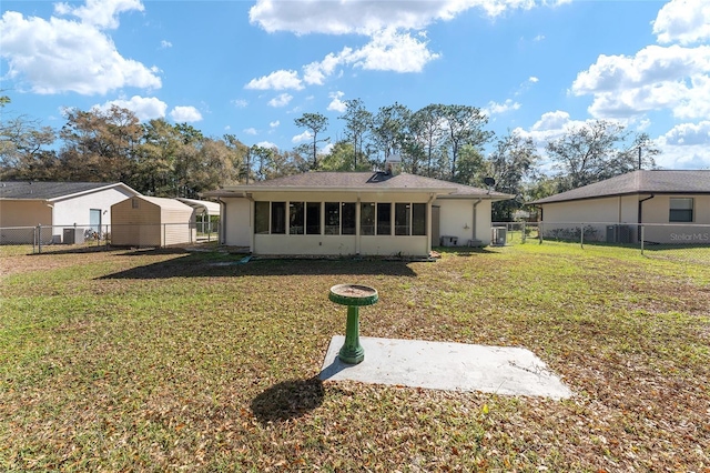 back of property featuring a yard, central AC, a fenced backyard, and a sunroom