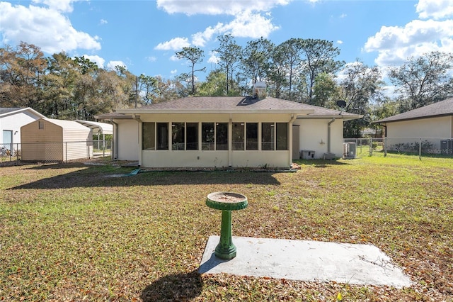 back of house with a sunroom, central air condition unit, a lawn, and fence