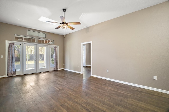 empty room featuring ceiling fan, a skylight, baseboards, french doors, and dark wood-style floors