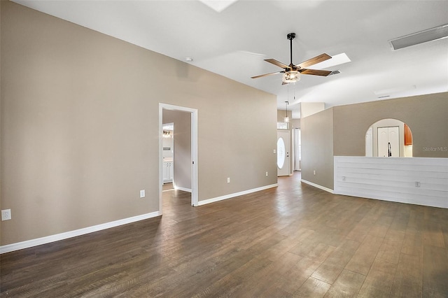 empty room featuring a ceiling fan, lofted ceiling, dark wood finished floors, and baseboards