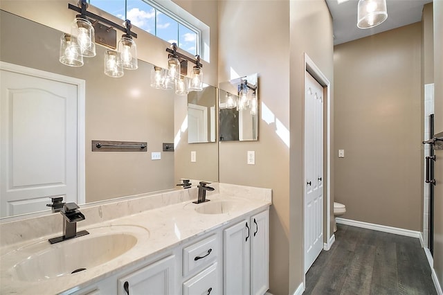 full bath with wood finished floors, a sink, toilet, and double vanity