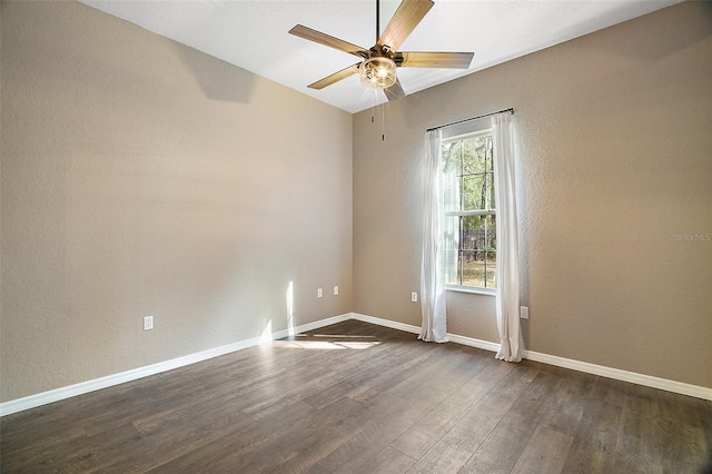 unfurnished room with dark wood-style floors, baseboards, a ceiling fan, and a textured wall