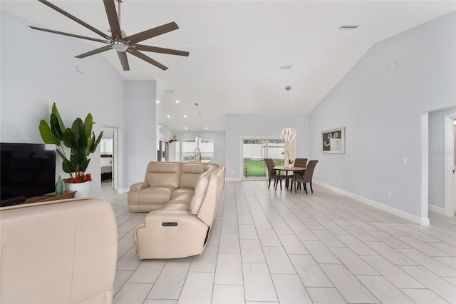 living area featuring light tile patterned floors, high vaulted ceiling, ceiling fan, visible vents, and baseboards