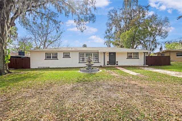 view of front of house featuring a front yard, fence, and stucco siding