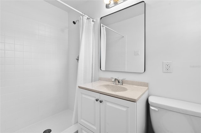full bath with toilet, vanity, and a tile shower