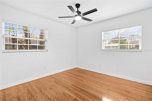 unfurnished room featuring a ceiling fan, wood finished floors, and baseboards