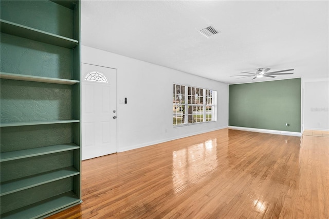 unfurnished living room with visible vents, baseboards, ceiling fan, and wood finished floors