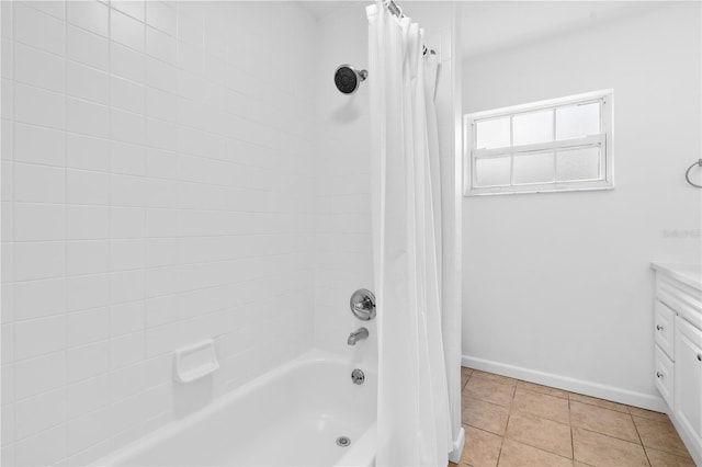 full bath featuring tile patterned flooring, shower / tub combo, vanity, and baseboards