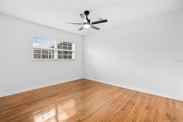 spare room featuring baseboards, light wood-style flooring, and a ceiling fan