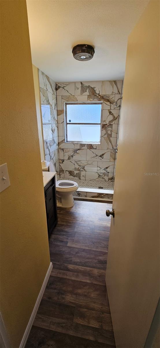31 Roosevelt Blvd, Beverly Hills, FL 34465 - full bathroom with vanity, wood finished floors, baseboards, a shower stall, and toilet