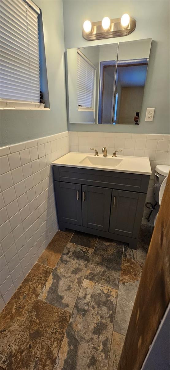 31 Roosevelt Blvd, Beverly Hills, FL 34465 - bathroom featuring a wainscoted wall, toilet, tile walls, and vanity