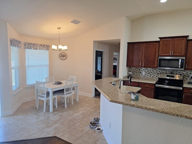 kitchen with light tile patterned floors, stainless steel appliances, a sink, vaulted ceiling, and backsplash