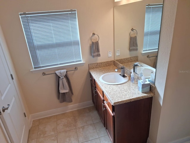 bathroom featuring tile patterned flooring, baseboards, and vanity