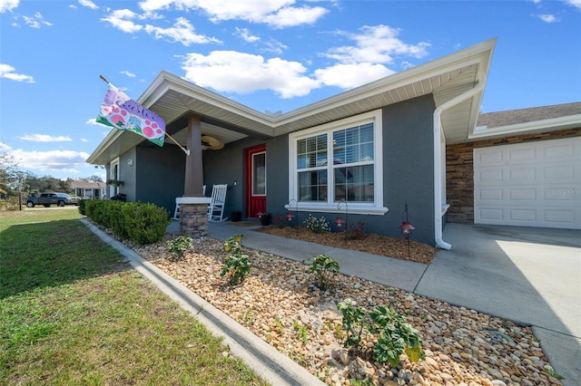 ranch-style home featuring stucco siding, a porch, concrete driveway, a garage, and a front lawn