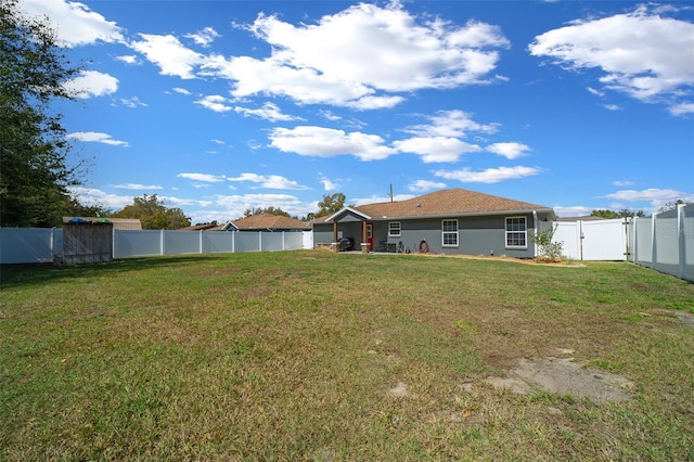 view of yard with a fenced backyard and a gate