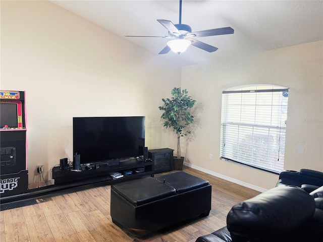 living room featuring ceiling fan, baseboards, and wood finished floors