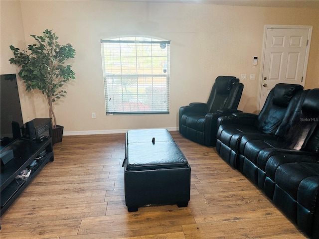 living area with baseboards and wood finished floors