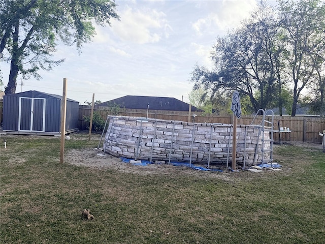 view of yard with an outbuilding, a shed, a swimming pool, and a fenced backyard