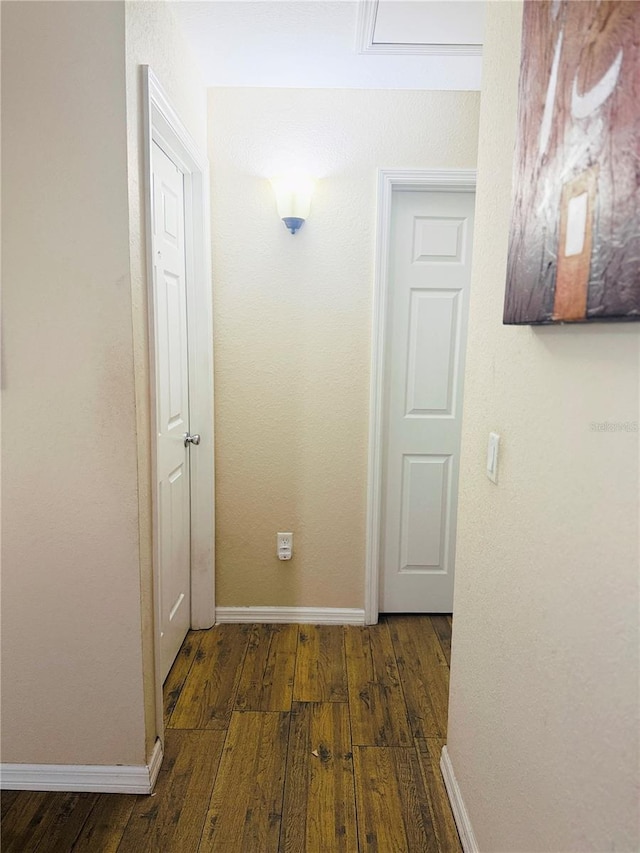 hall featuring hardwood / wood-style flooring and baseboards