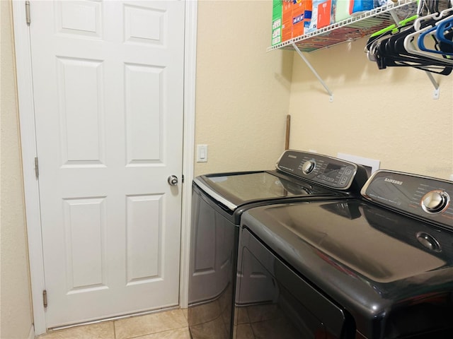 clothes washing area with laundry area, light tile patterned flooring, and washer and dryer