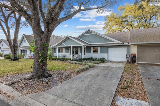 view of front of home featuring a porch, an attached garage, brick siding, driveway, and stucco siding