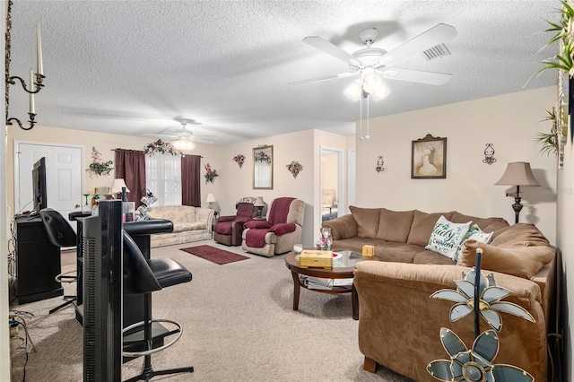 living area with a ceiling fan, light carpet, visible vents, and a textured ceiling
