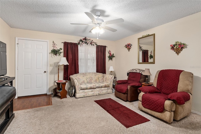 carpeted living area with ceiling fan and a textured ceiling