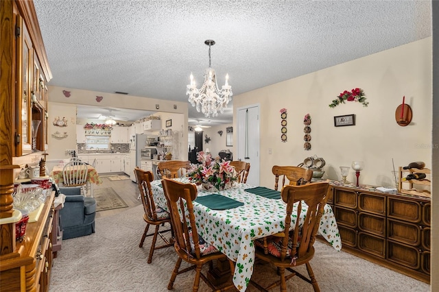 dining room featuring light colored carpet, a textured ceiling, and ceiling fan with notable chandelier