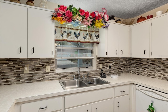 kitchen featuring dishwasher, light countertops, a textured ceiling, and a sink