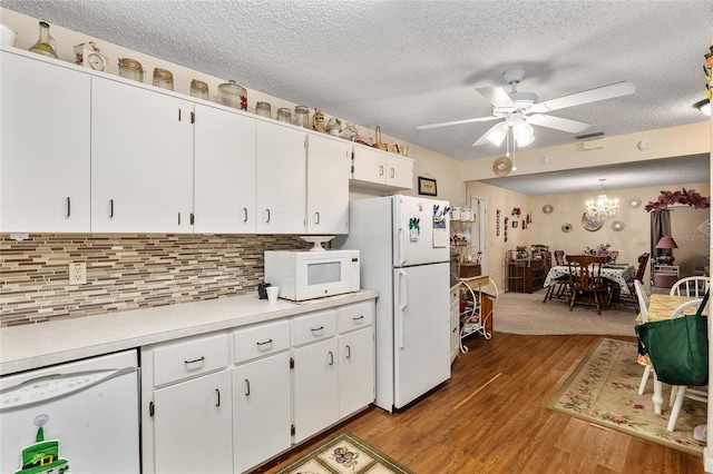 kitchen featuring tasteful backsplash, light countertops, white cabinetry, wood finished floors, and white appliances
