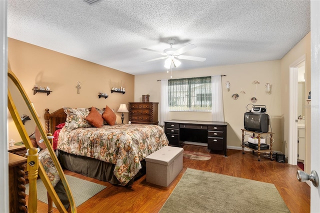 bedroom with ceiling fan, a textured ceiling, and wood finished floors