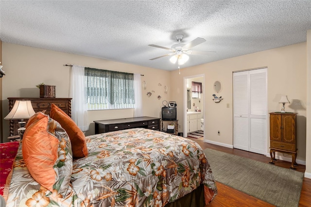 bedroom with ensuite bathroom, a ceiling fan, a textured ceiling, wood finished floors, and baseboards