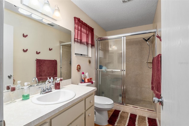 bathroom featuring visible vents, toilet, a shower stall, a textured ceiling, and vanity