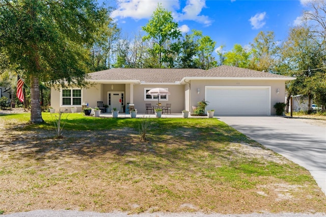 ranch-style house featuring a garage, driveway, a front lawn, and stucco siding