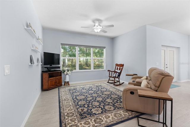 living room with french doors, ceiling fan, and baseboards