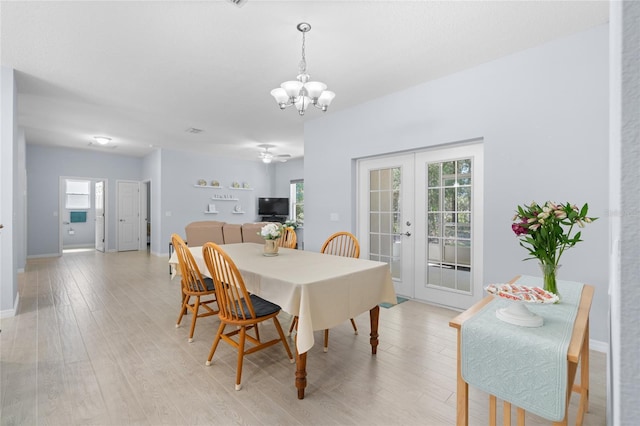 dining room with baseboards, french doors, a chandelier, and light wood-style floors