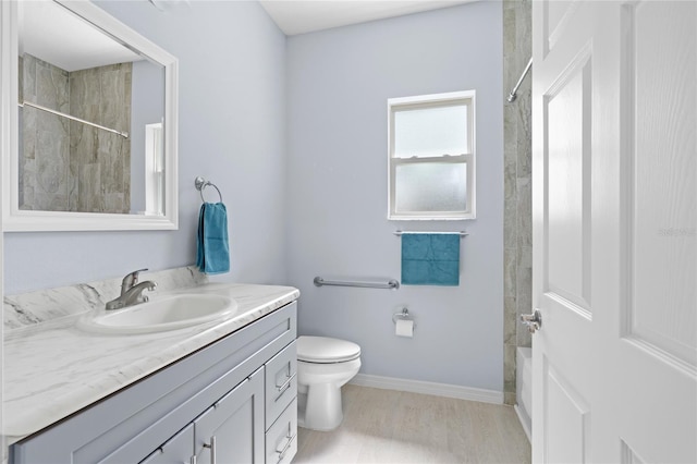 full bathroom with toilet, wood finished floors, vanity, baseboards, and walk in shower