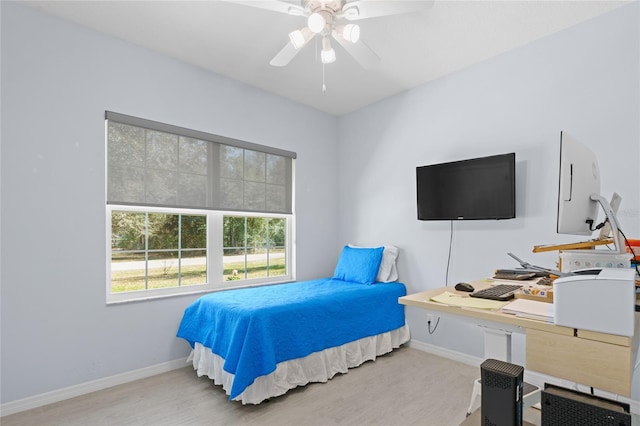 bedroom with ceiling fan, baseboards, and wood finished floors