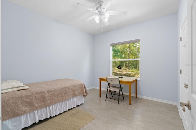 bedroom featuring light wood-type flooring, baseboards, and a ceiling fan