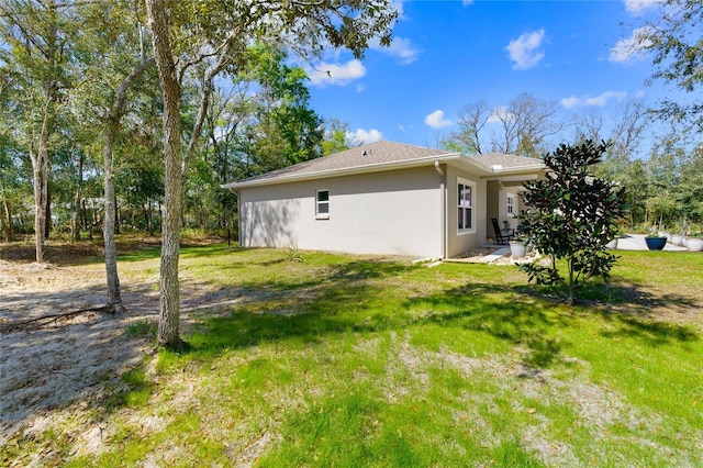 view of property exterior with stucco siding and a yard