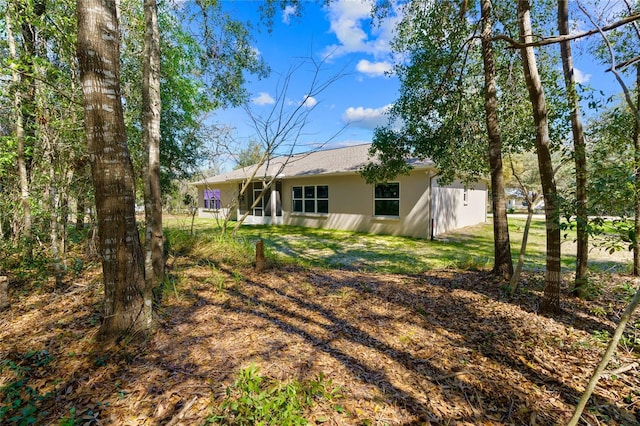 rear view of property featuring a lawn